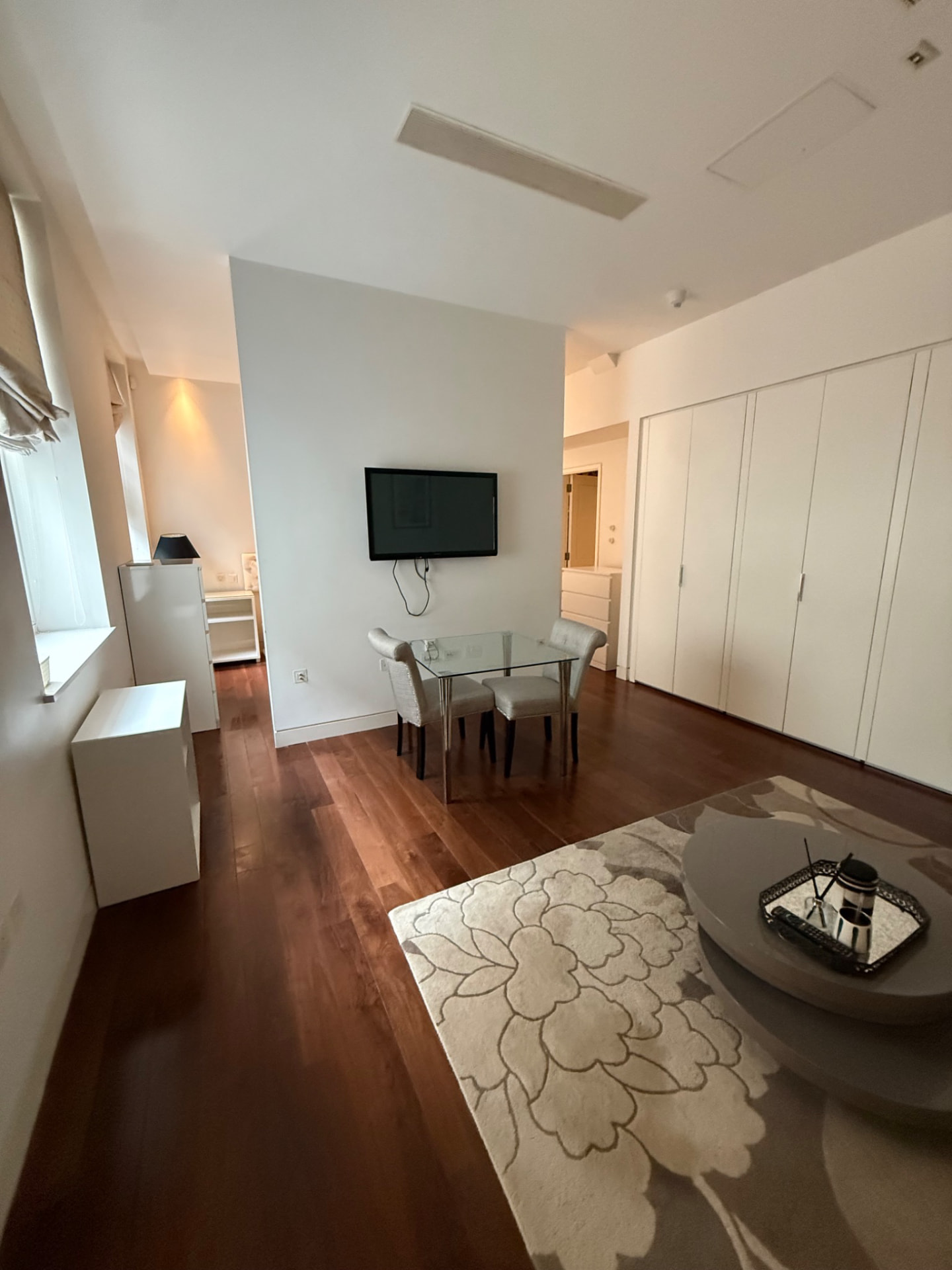 Living and dining area with wooden flooring and a rug in a London flat